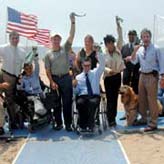 Officials and accessiblity advocates cut ribbon on beach mat