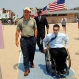Parks Commissioner Benepe and Parks Accessibility Coordinator try outh the beach mat