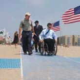 Parks Commissioner Benepe and Parks Accessibility Coordinator try outh the beach mat