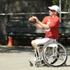 Man in wheelchair playing football in park