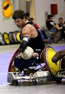 Man in a wheelcahir playing rugby