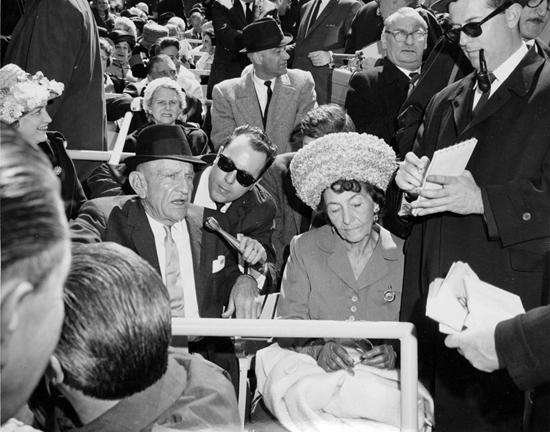 Image of Mets manager Casey Stengel and his wife Edna with reporters at Shea Stadium Opening Day, April 16, 1964. Neg. 31964.2