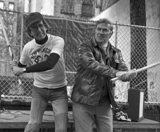 Image of Men take a break from a Parks-sponsored stickball tournament on Thompson Street in Manhattan to pose for the camera. October 1977. Neg. 53027.11