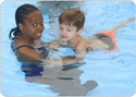 Instructor teaching a kid to swim