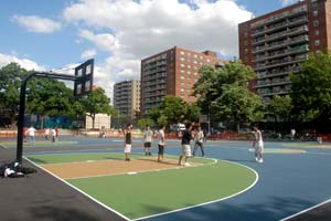 A group of youngsters play basketball on a colorful basketball court in Windmuller Park