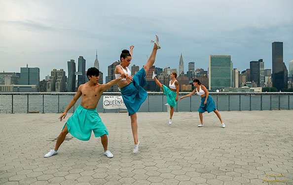 Four dancers perform a routine at the waterfront space which features a view of the Midtown Manhattan skyline.