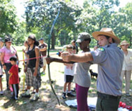 Urban Park Ranger instructs parkgoer in the art of archery.